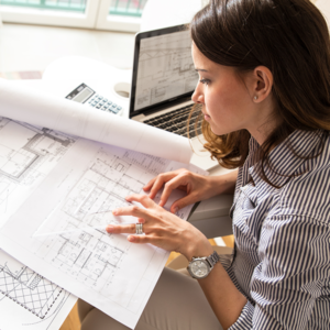 A young woman overlooks architectural plans