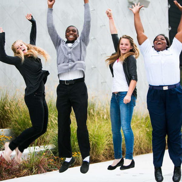 A young group of diverse professionals jump for joy