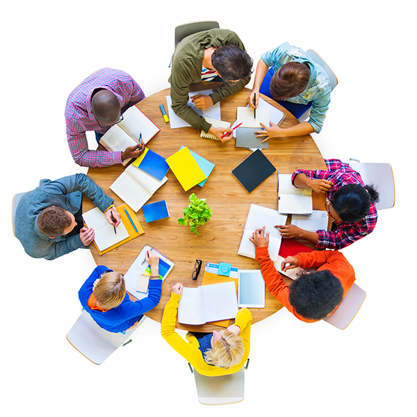 Overhead shot of several people sitting at a round table working with books and notes